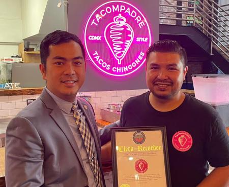 Outreach staff presenting a certificate of recognition to Tacompadre.
